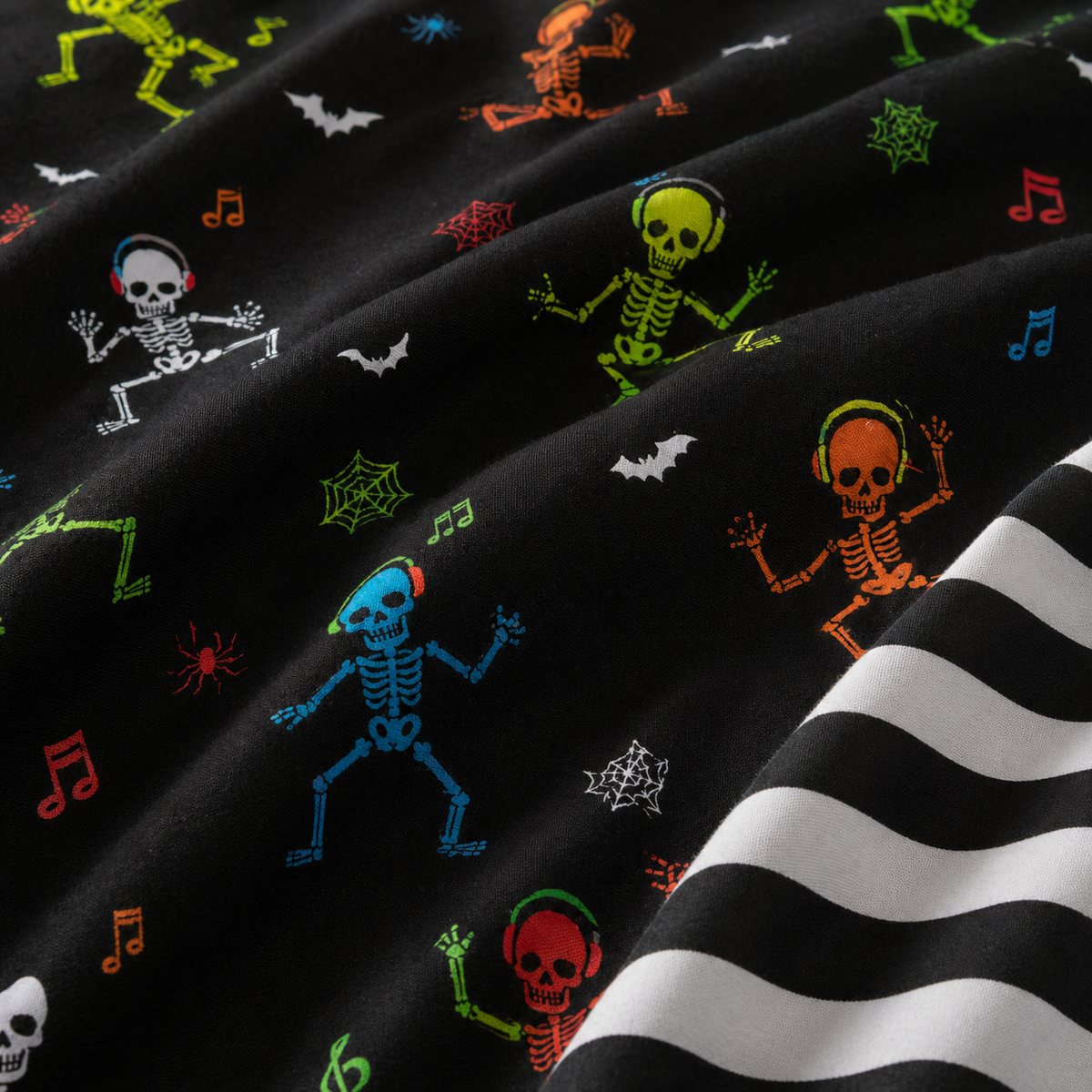 Macro close-up of black Dancing Skeletons polycotton fabric with neon skeleton and bat print