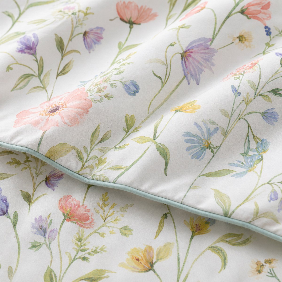 Macro close-up of the Gardenia smooth cotton duvet cover fabric with delicate wildflower stems