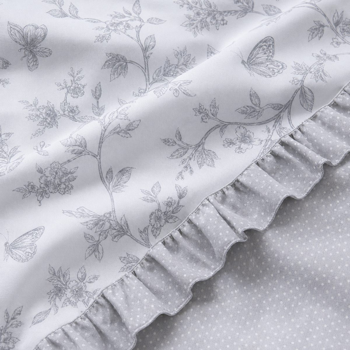 Macro close-up of the Kristen grey polycotton duvet fabric with floral print and dotted reverse