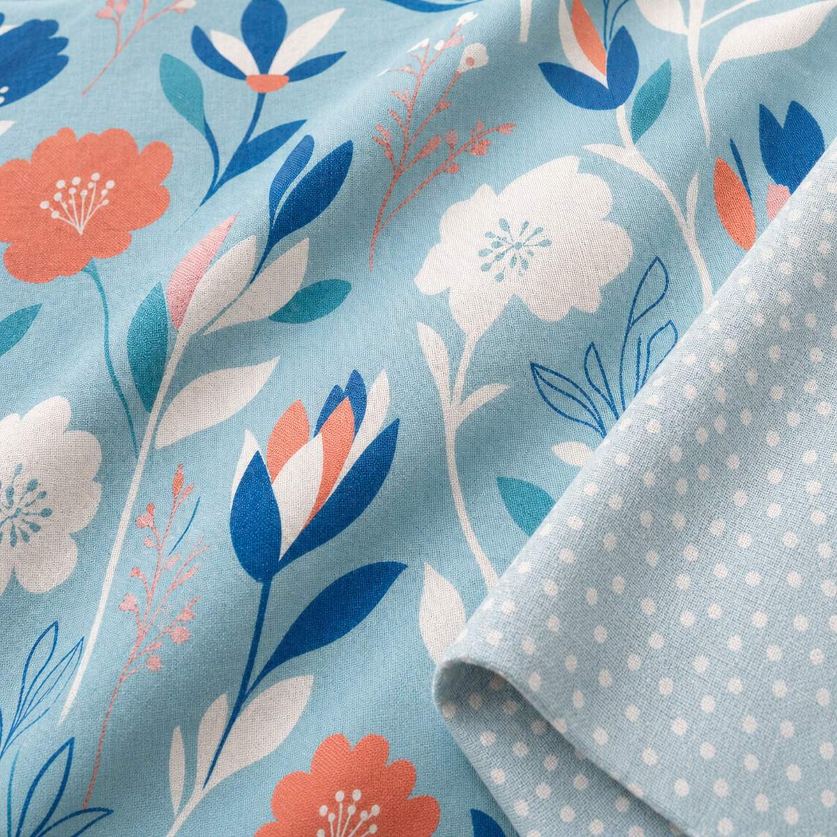 Macro close-up of the Luna duck egg polycotton duvet fabric with floral print and spotted reverse