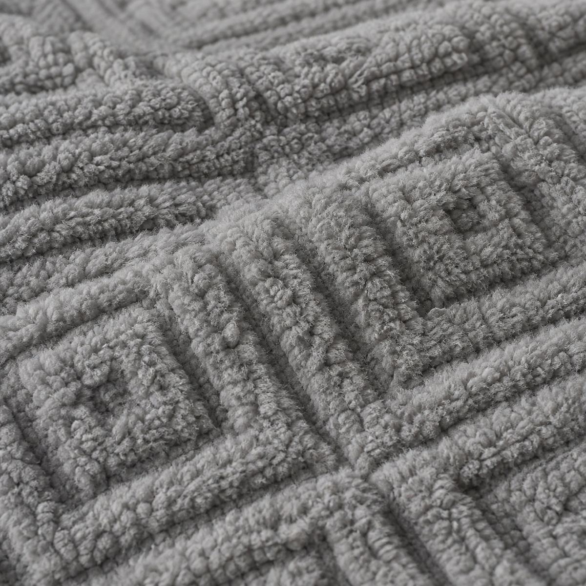 Macro close-up of the grey Romo microfibre fleece fabric with raised diamond pattern