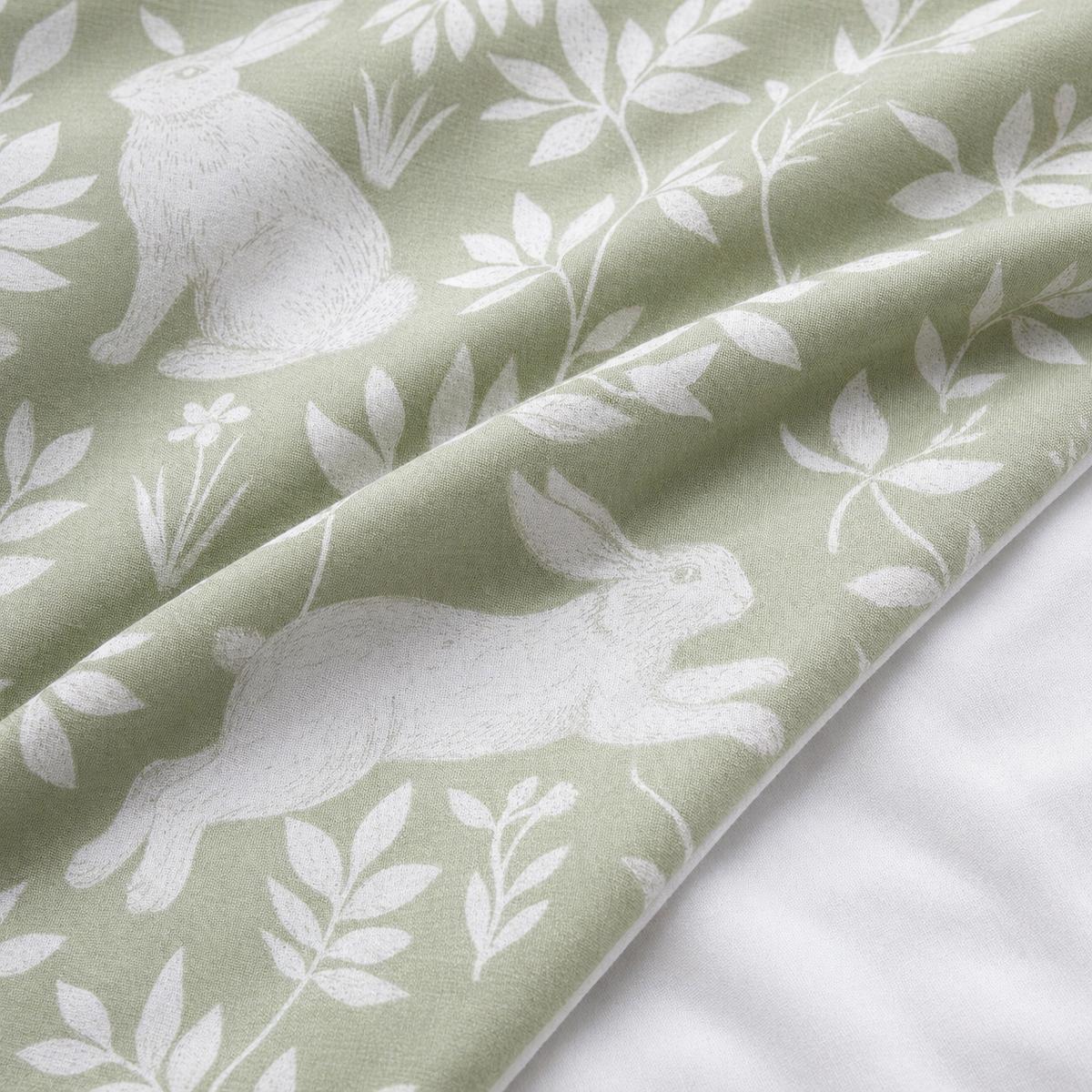 Macro close-up of the Spring Rabbits green polycotton duvet fabric with rabbit and leaf detail