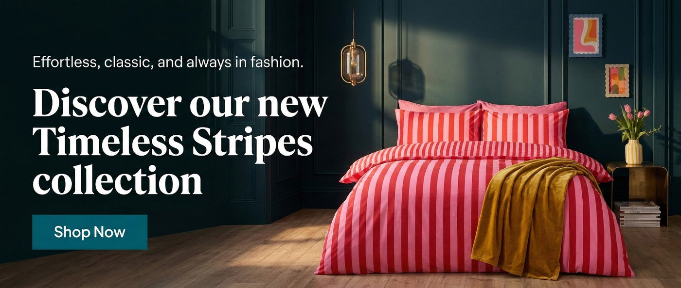 Bedroom with red and white striped bedding, 'Timeless Stripes' collection advertisement.