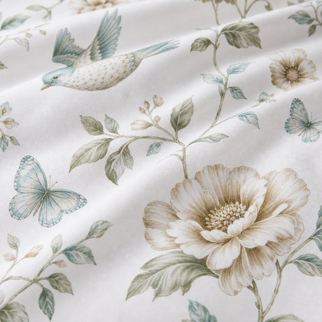 Macro close-up of the green bird and floral Amelle polycotton duvet cover fabric