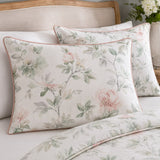 Close-up of Campion cotton sateen pillowcases with muted floral print and pink piping