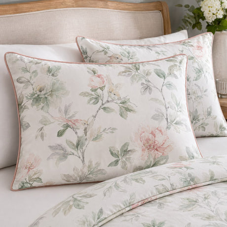 Close-up of Campion cotton sateen pillowcases with muted floral print and pink piping