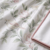 Macro close-up of Campion cotton sateen fabric with soft floral and bird motif