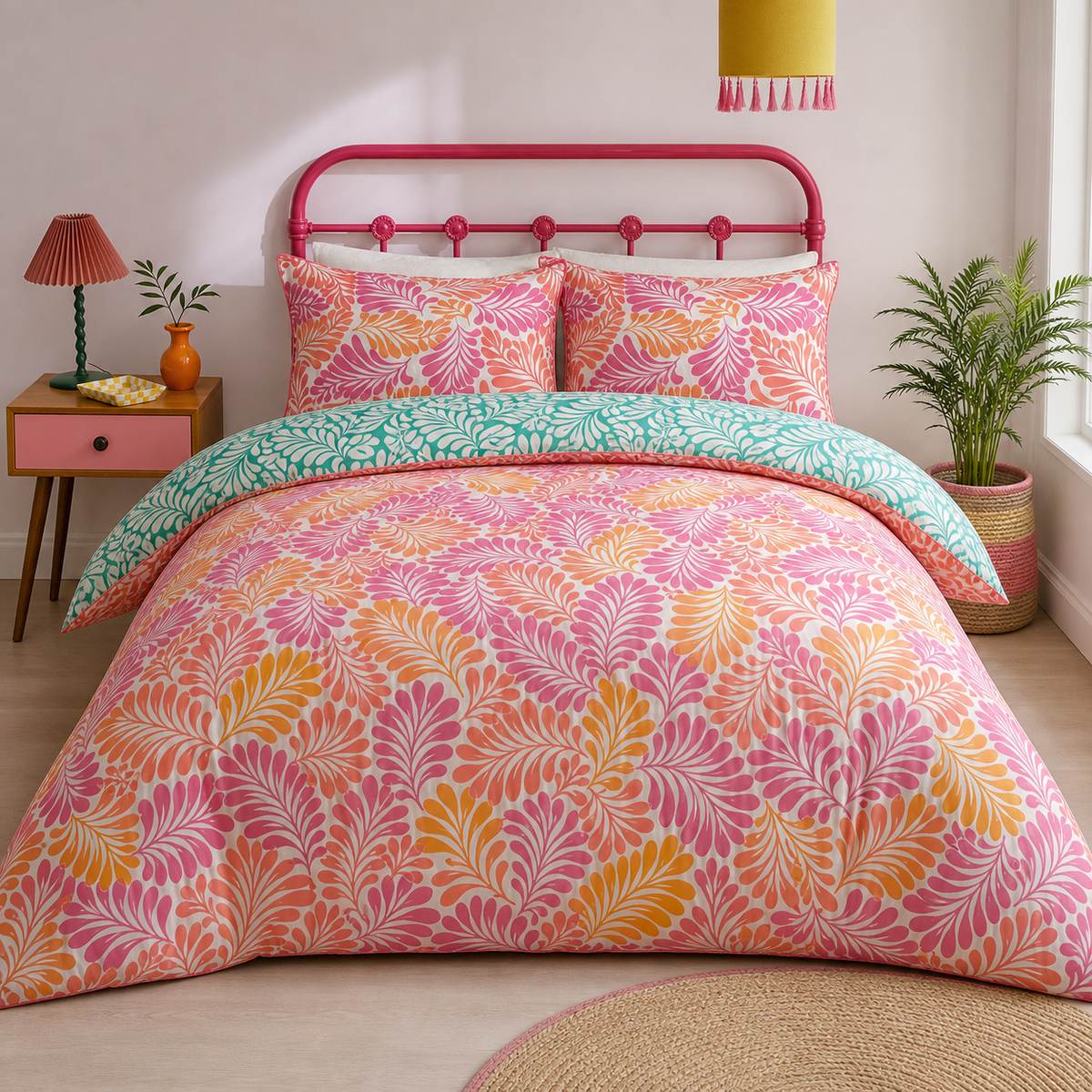Carmen Pink cotton duvet cover set styled on a bright bedroom bed with teal reverse fold