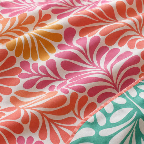 Macro close-up of Carmen Pink cotton duvet cover fabric with coral orange and pink fan leaves