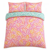 Overhead flat lay of the Carmen Pink cotton duvet cover set with two pillows and teal reverse fold