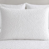 Close-up of a white Collier jacquard floral pillowcase showing the raised textured pattern