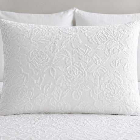 Close-up of a white Collier jacquard floral pillowcase showing the raised textured pattern