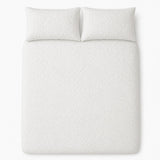 Overhead flat lay of the white Collier jacquard floral duvet cover set with two pillows