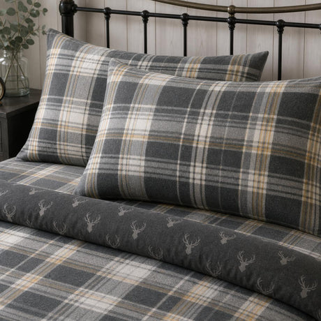 Close-up of Connolly charcoal check brushed cotton pillowcases showing the tartan pattern