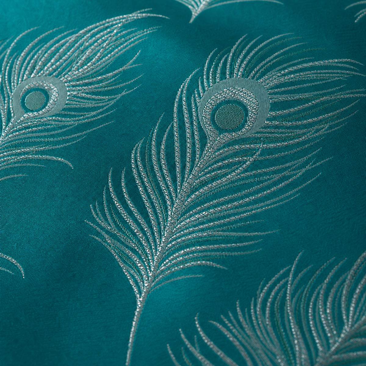 Macro close-up of the teal and silver Dandy jacquard polycotton peacock feather fabric