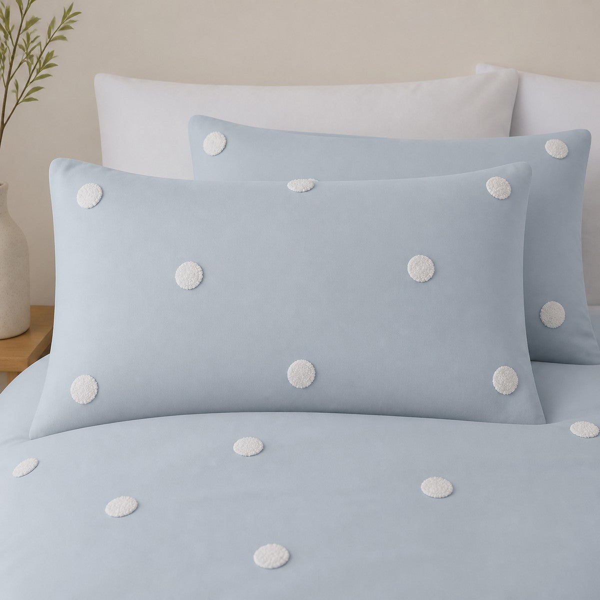 Close-up of Dot Garden duck egg cotton pillowcases with raised white dot detail