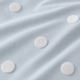 Macro close-up of the duck egg cotton fabric and raised white dots on the Dot Garden duvet cover