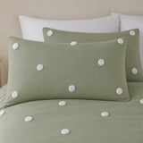 Close-up of Dot Garden sage cotton pillowcases with raised white dot detail