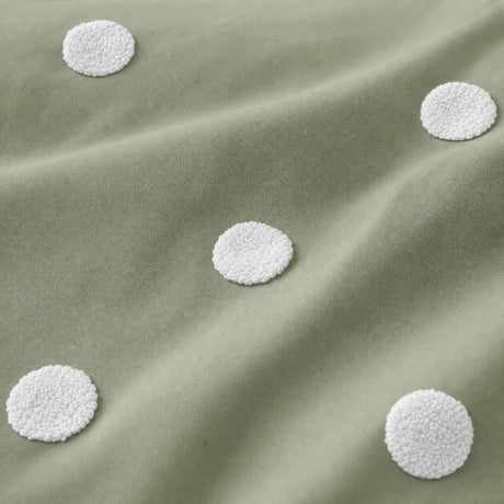 Macro close-up of the sage cotton fabric and raised white dots on the Dot Garden duvet cover