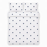 Overhead flat lay of the Dot Garden Cotton Duvet Cover Set in white + navy with two matching pillowcases