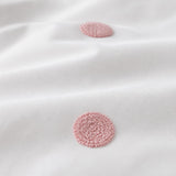 Macro close-up of the white + pink fabric on the Dot Garden Cotton Duvet Cover Set