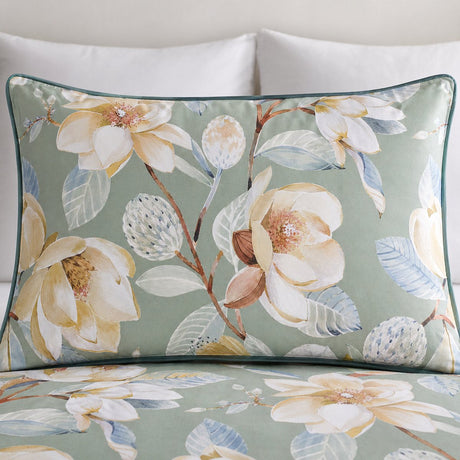 Close-up of an Eleanor green floral pillowcase with cream flowers and blue green leaves