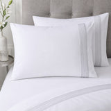 Close-up of Embroidered Band white cotton pillowcases with narrow silver stitched bands
