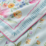 Macro close-up of the Festival duck egg cotton duvet cover fabric with floral border detail