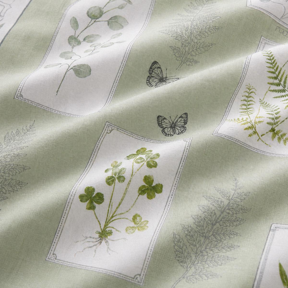 Macro close-up of the Floral Garden green polycotton duvet fabric with botanical panel detail