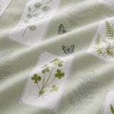 Macro close-up of the Floral Garden green polycotton duvet fabric with botanical panel detail