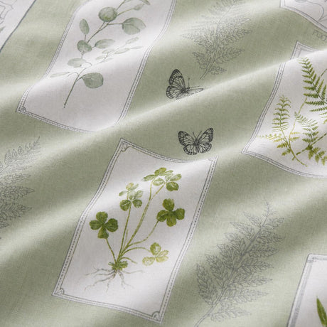 Macro close-up of the Floral Garden green polycotton duvet fabric with botanical panel detail