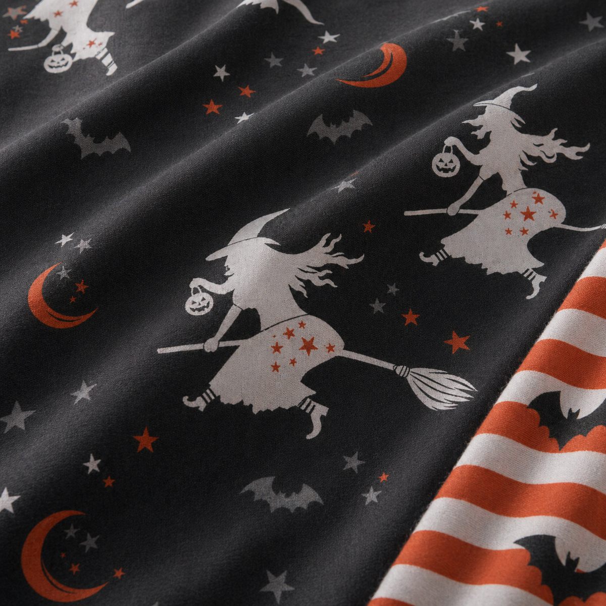 Macro close-up of Flying Witches polycotton fabric with white witch and bat print