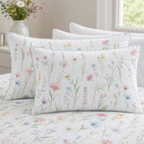 Close-up of Gardenia cotton pillowcases showing the pastel floral print and aqua piping