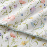 Macro close-up of the Gardenia smooth cotton duvet cover fabric with delicate wildflower stems
