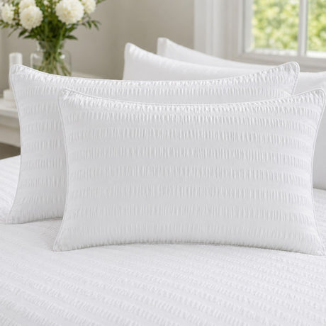 Close-up of Honley white seersucker pillowcases showing the raised puckered stripe texture