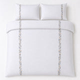 Overhead flat lay of the Julianna Embroidered 100% Cotton Duvet Cover Set in white with two matching pillowcases