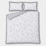 Overhead flat lay of the Kristen grey frill duvet cover set with two matching pillows