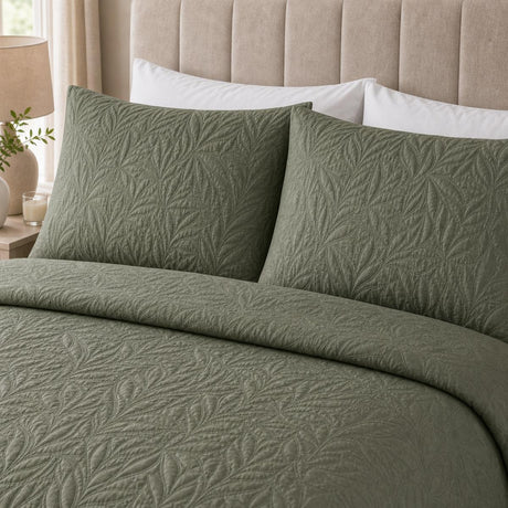 Close-up of Luana Dark Green pillowcases showing the raised leafy stitched pattern