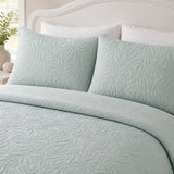 Close-up of Luana Green pillowcases showing the raised leafy stitched pattern