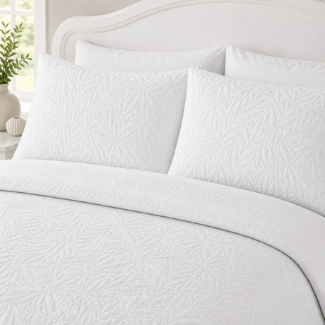 Close-up of Luana White pillowcases showing the raised leafy stitched pattern