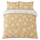 Overhead flat lay of the Mishka Reversible Floral Gold Polycotton Duvet Cover Set with two matching pillowcases