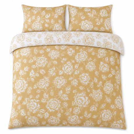 Overhead flat lay of the Mishka Reversible Floral Gold Polycotton Duvet Cover Set with two matching pillowcases