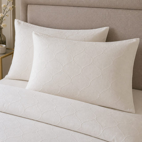 Close-up of Montez Jacquard Beige pillowcases showing the subtle raised ogee texture