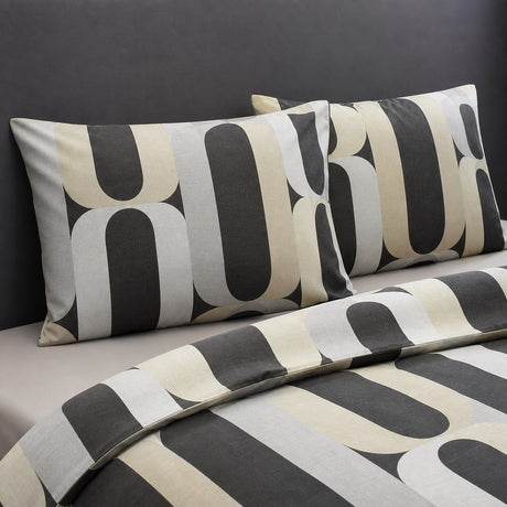 Close-up of Orea charcoal polycotton pillowcases showing the rounded geometric pattern