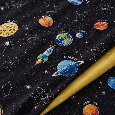Macro close-up of the Outer Space kids duvet cover fabric with planets and yellow reverse detail