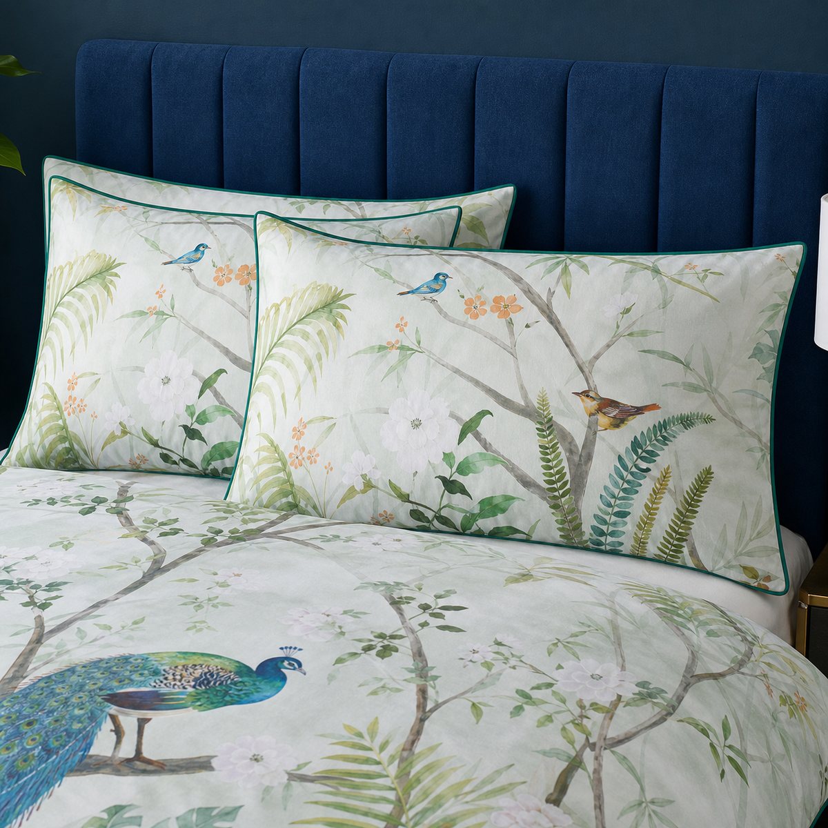 Close-up of Peacock Jungle green pillowcases with tropical leaves and peacock print