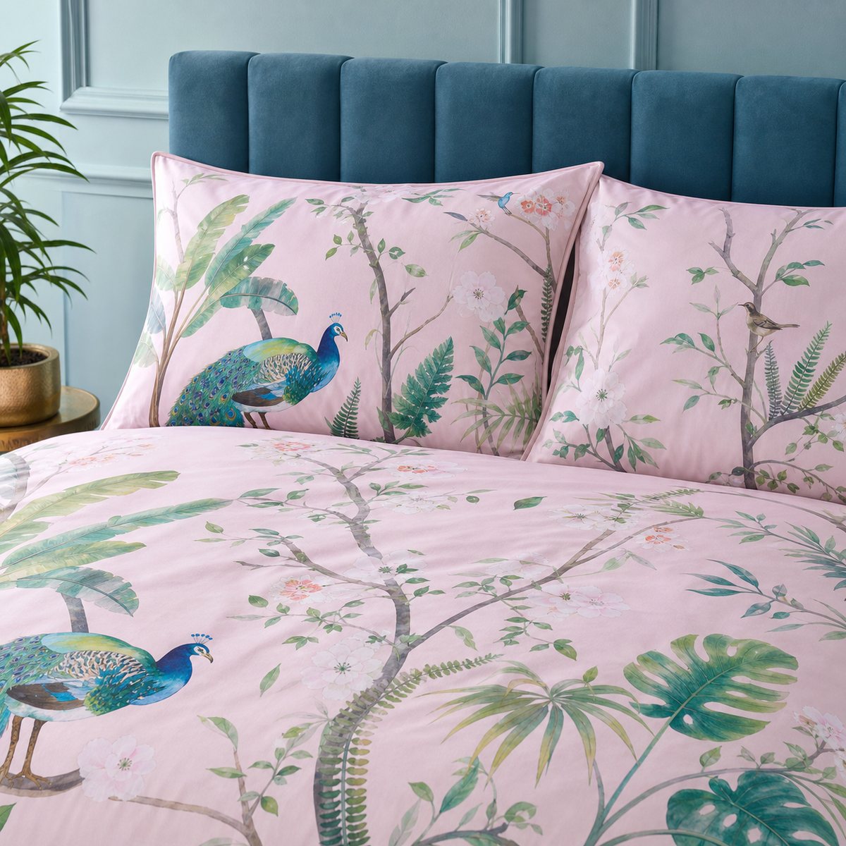 Close-up of Peacock Jungle pink pillowcases with tropical leaves and peacock print