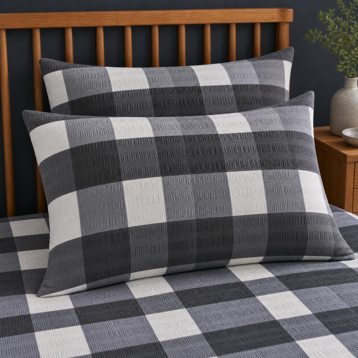 Close-up of Seersucker Gingham charcoal pillowcases showing the raised puckered check texture