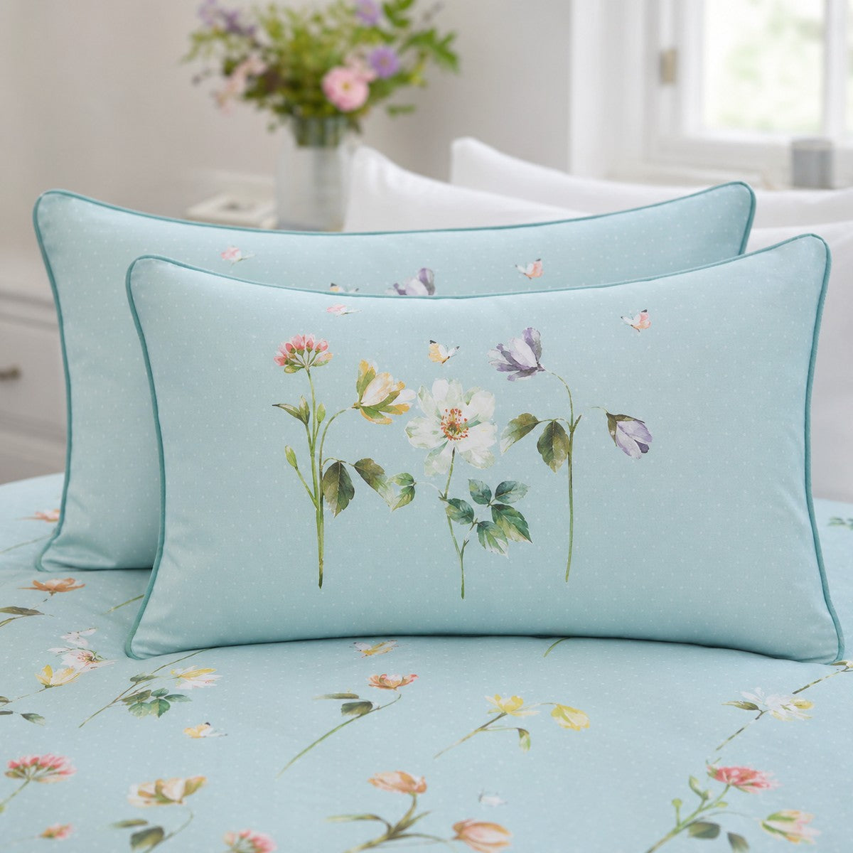 Close-up of Serenity duck egg floral pillowcases with teal piping