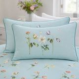 Close-up of Serenity duck egg floral pillowcases with teal piping